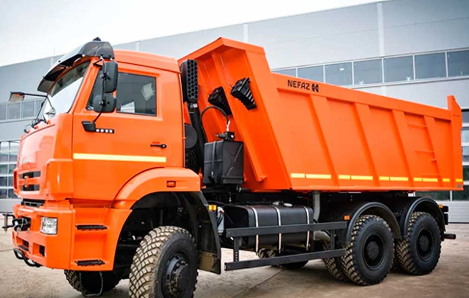 Orange NEFAZ dump truck with bed raised